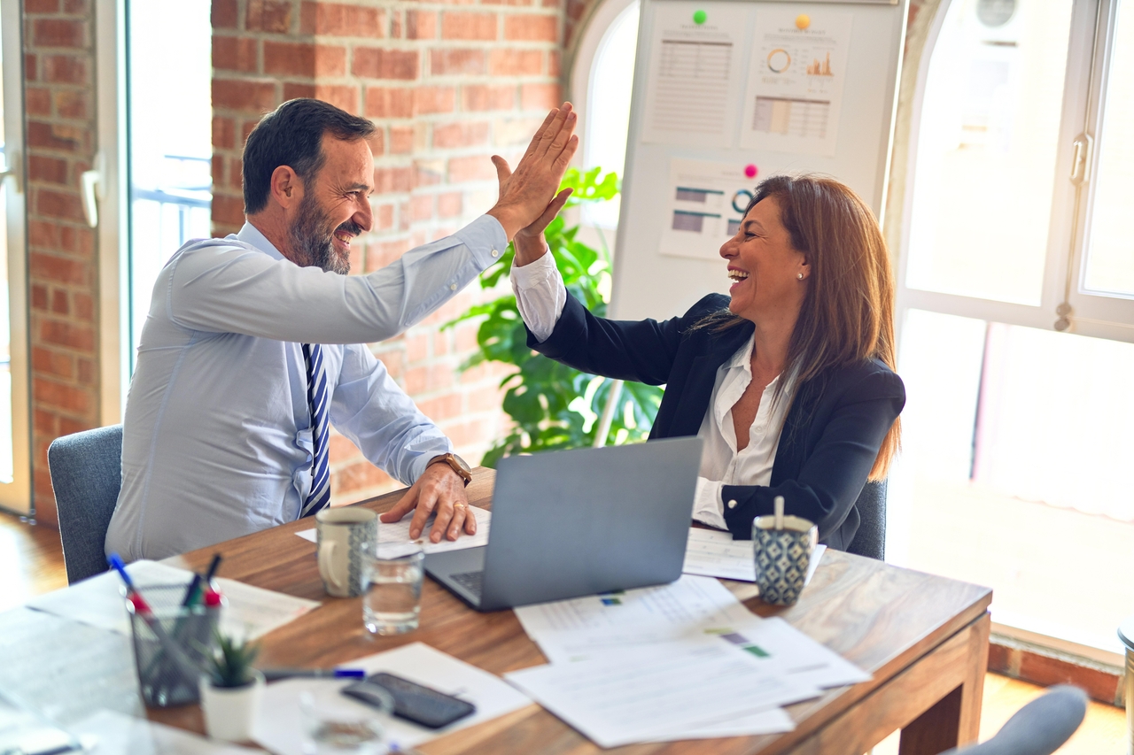 Man and woman at the office high five