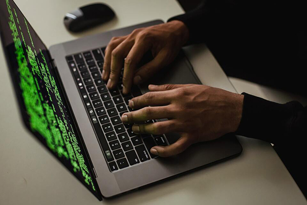 Hands typing on a laptop